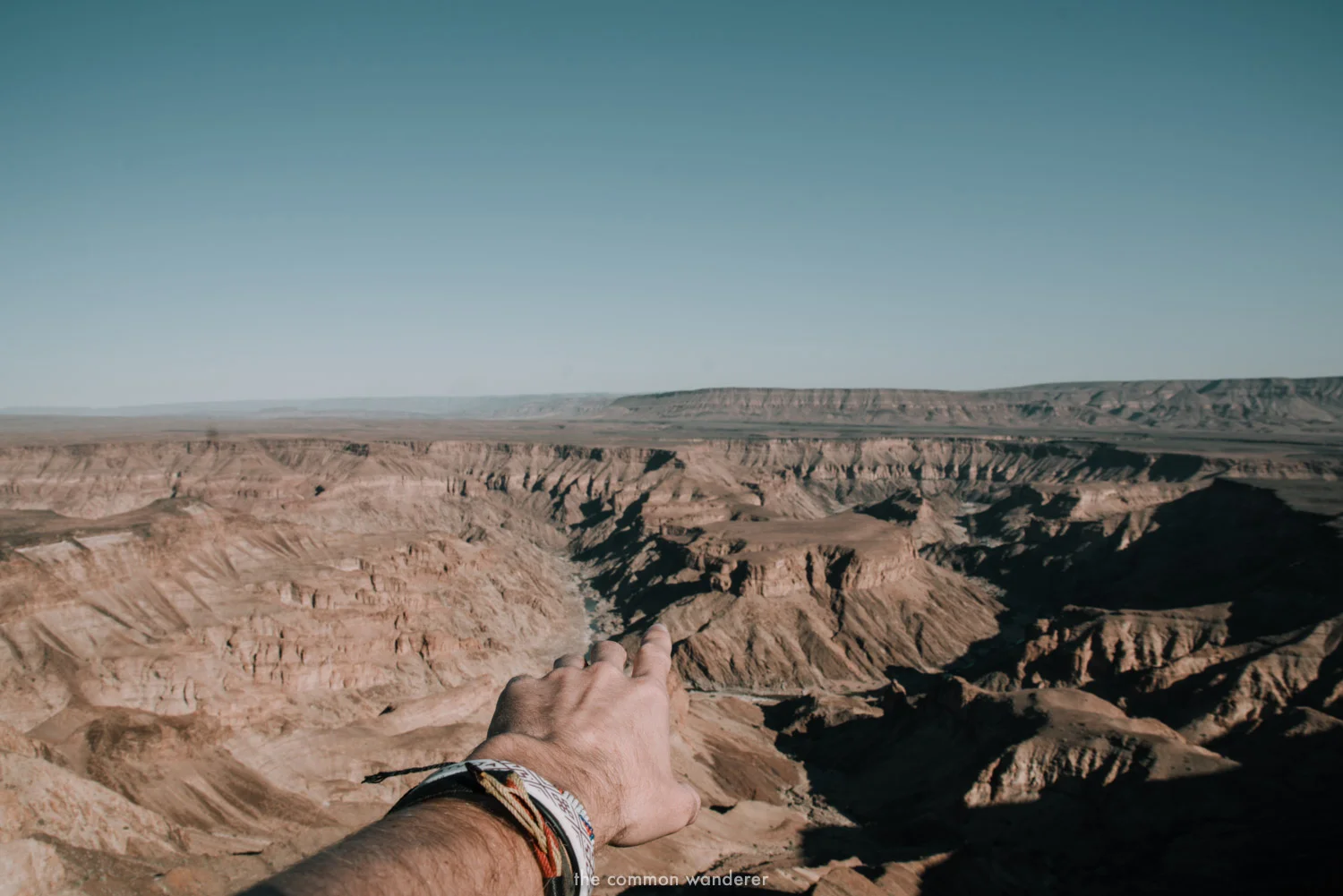 A man points into Fish River Canyon, Namibia