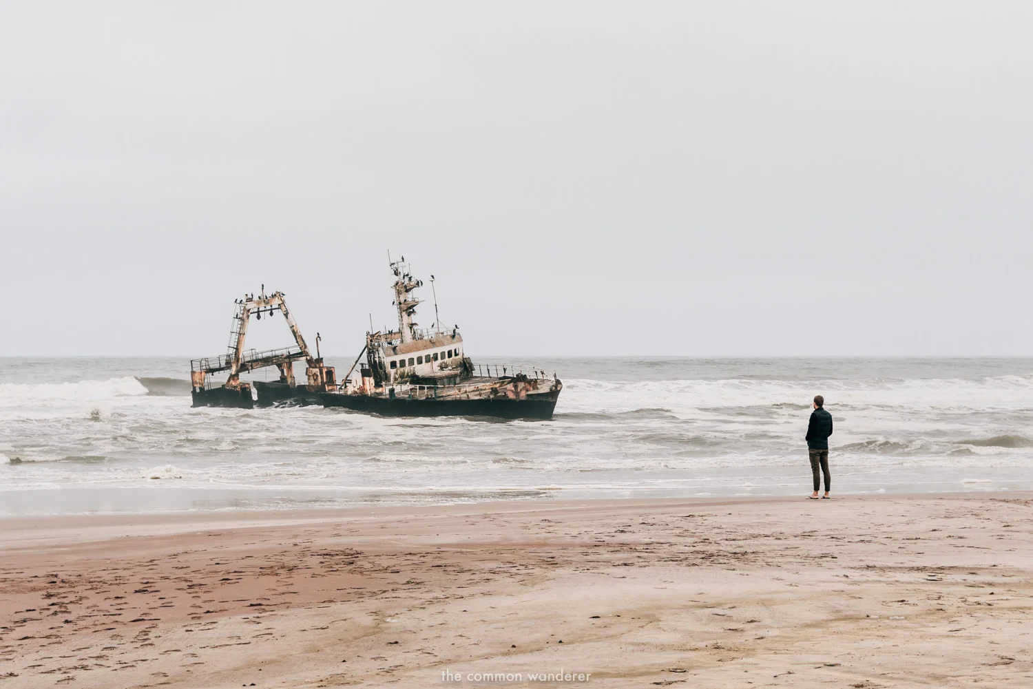 A man overlooks a shipwreck on the Shipwreck Coast, Namibia