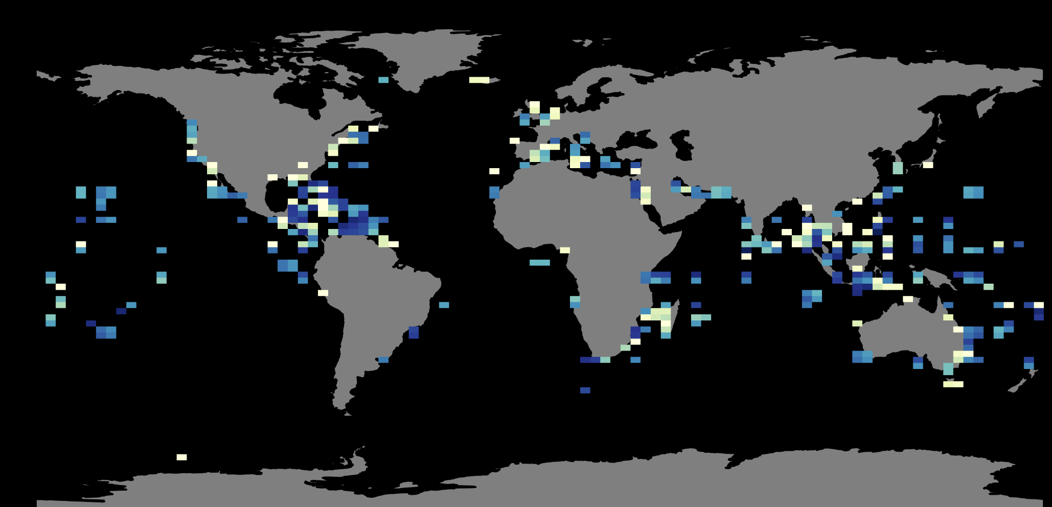 People cleaning up trash and debris along a beach during overcast weather, with mountains in the background and a dog in the distance.