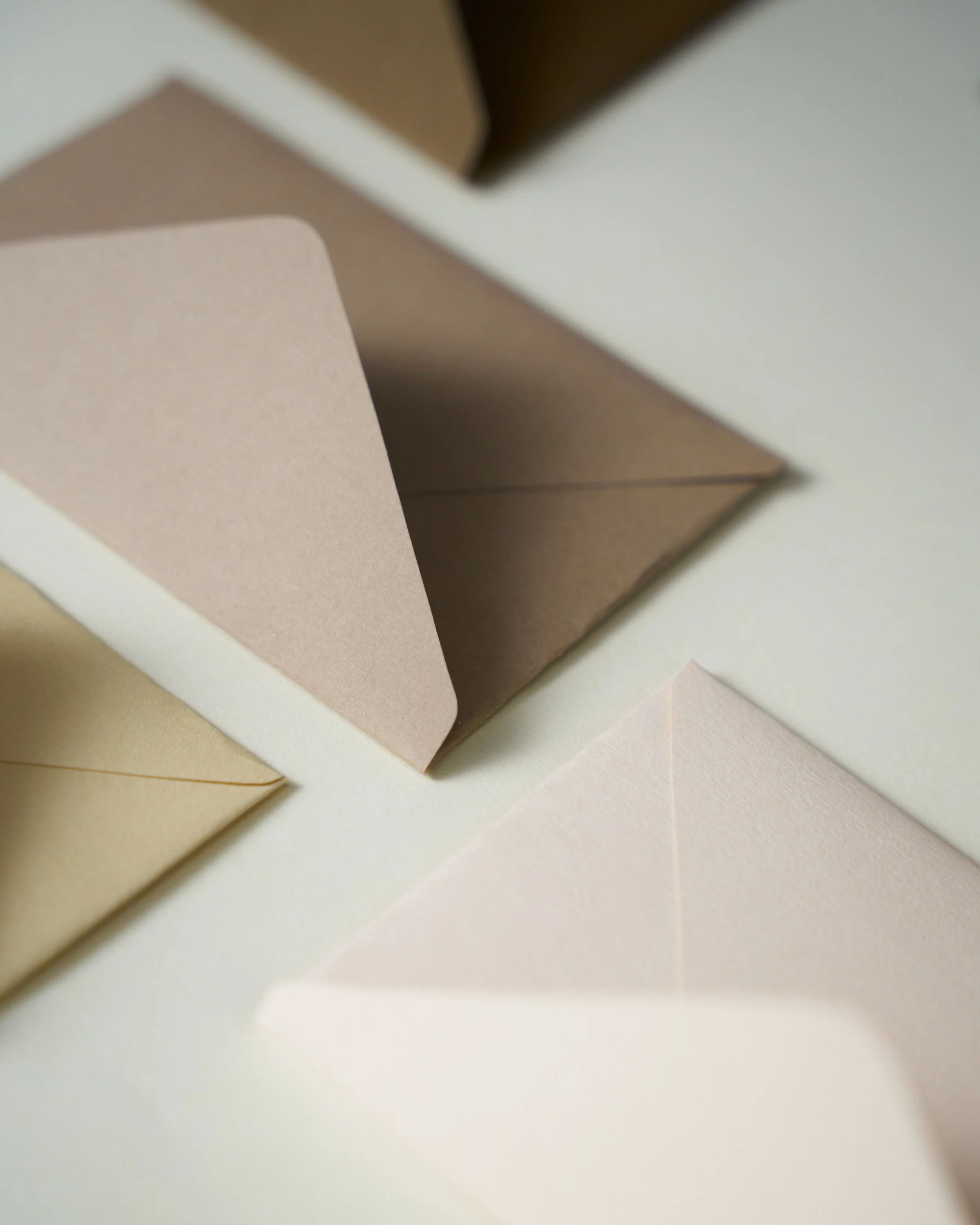 Cream and brown open envelopes on a white desk