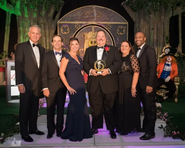 Amaury Piedra accepting his award with Tavistock Development Company executives