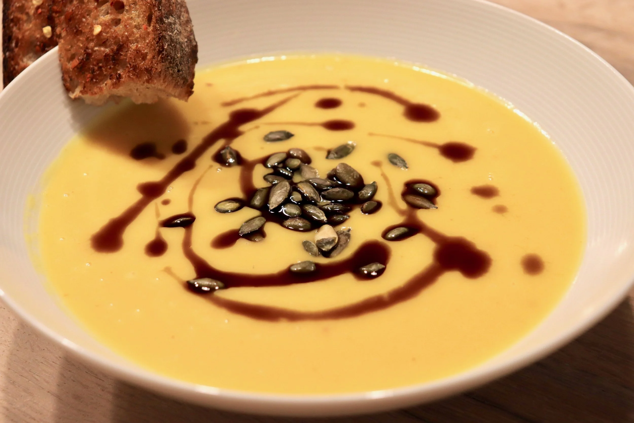Creamy butternut squash with pumpkin seed oil, toasted pumpkin seeds and chilli flaked sourdough crouton