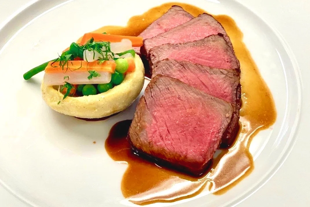 Roast sirloin of beef served medium, with turned artichoke and an assembling of garden vegetables