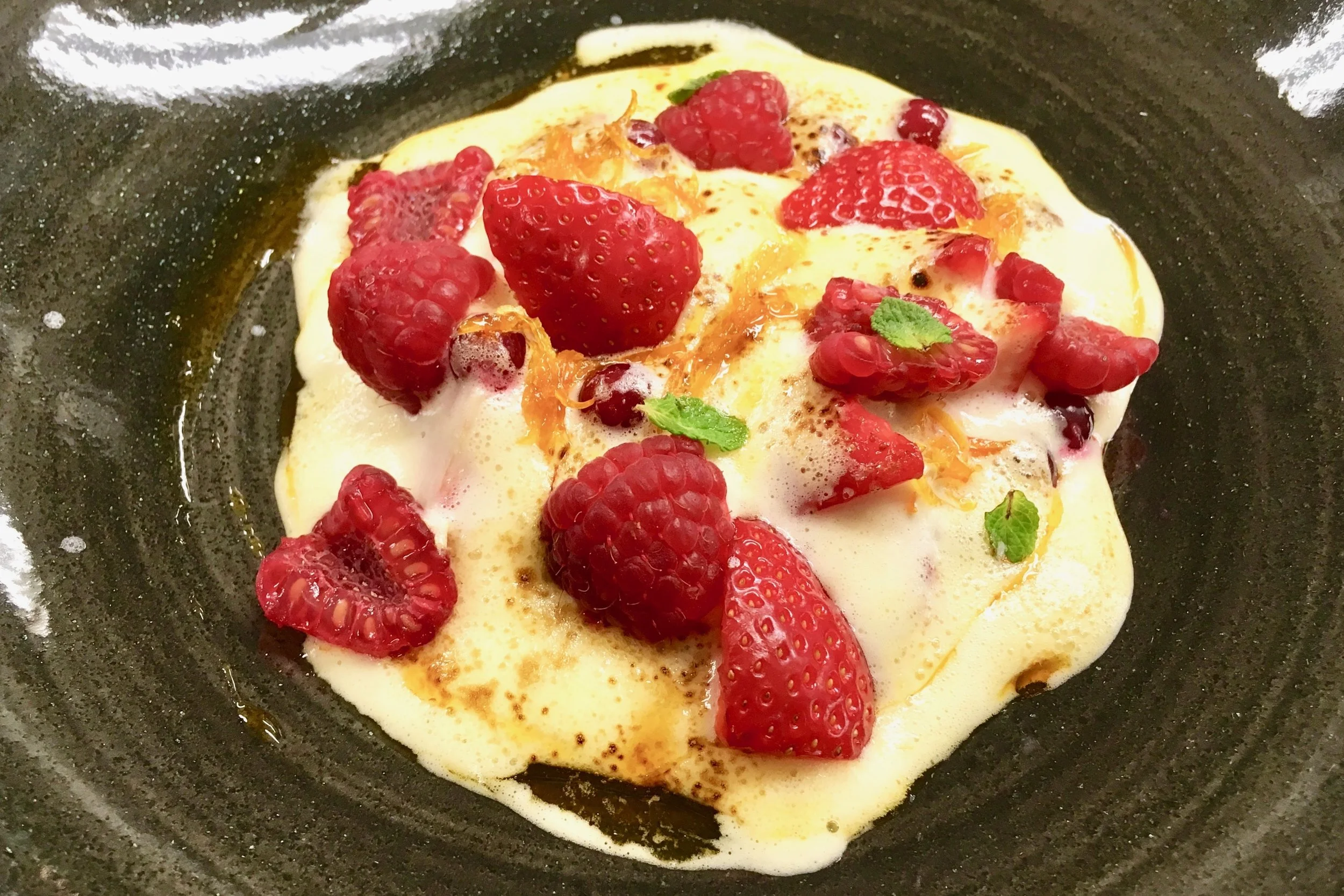 Red fruit gratin with a white wine sabayon and candied orange peel