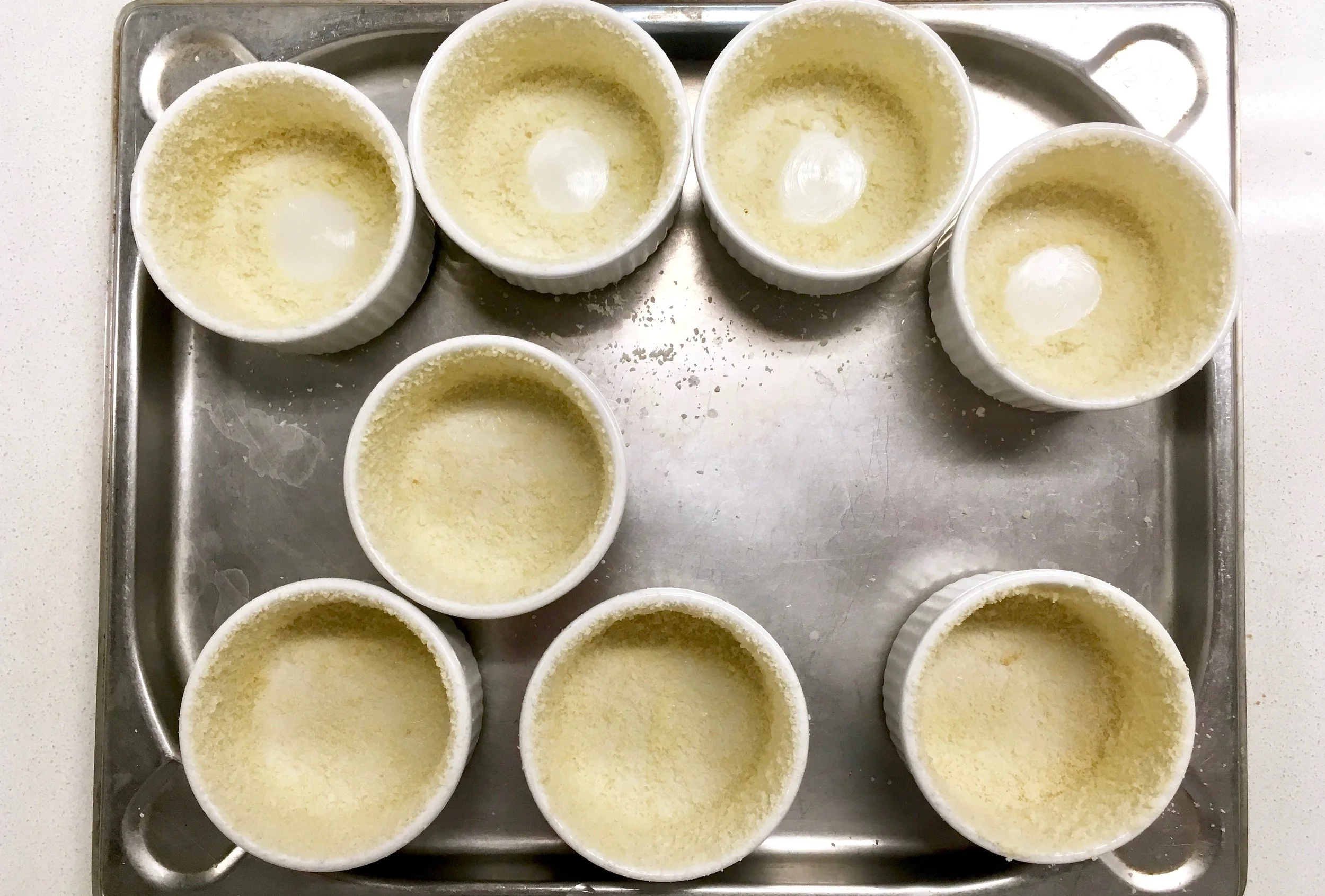 Double-buttered ramekin lined with breadcrumbs and Parmesan cheese