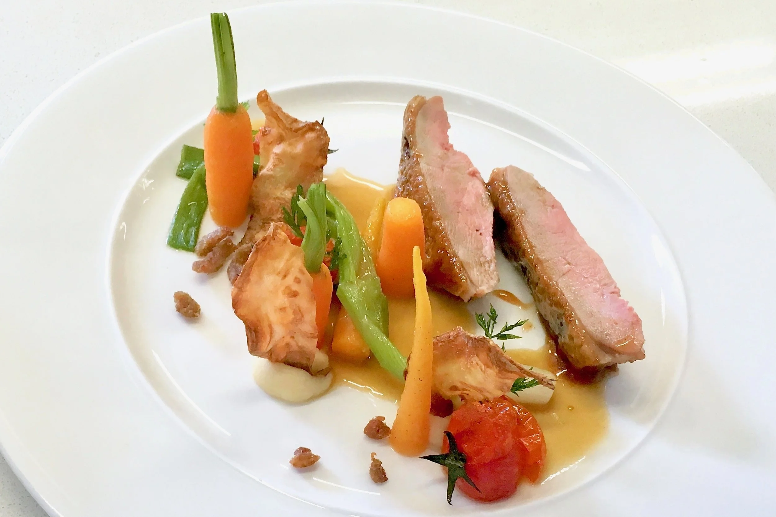 Chef’s roast duck on a white plate
