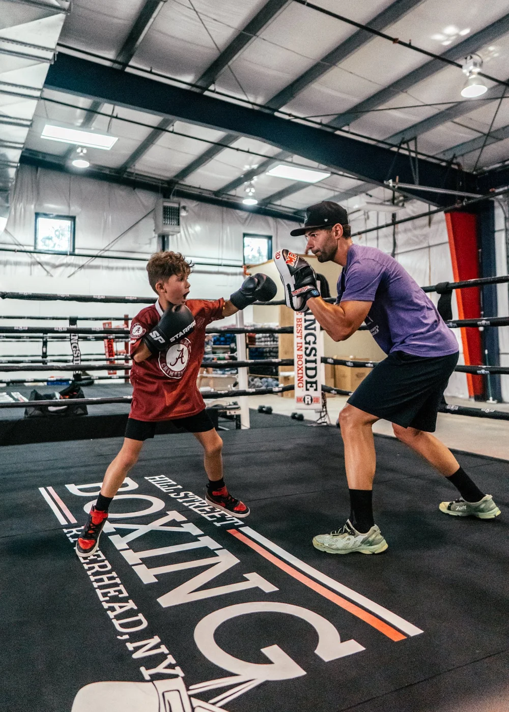 Doug Milano coaching a young boxer in the ring
