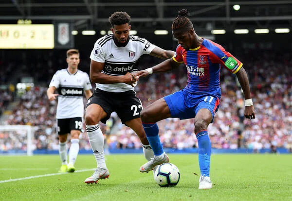 Cyrus Christie of Fulham and Wilfried Zaha of Crystal Palace during the Premier League match between Fulham FC and Crystal Palace at Craven Cottage on August 11, 2018 in London, United Kingdom. (Aug. 10, 2018 - Source: Justin Setterfield/Getty Images Europe)