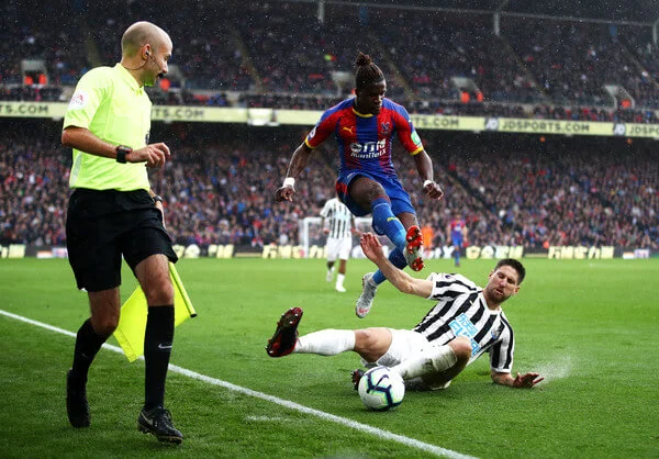 Wilfried Zaha of Crystal Palace jumps clear of a challenge from Federico Fernandez of Newcastle United during the Premier League match between Crystal Palace and Newcastle United at Selhurst Park on September 22, 2018 in London, United Kingdom. (Sept. 21, 2018 - Source: Julian Finney/Getty Images Europe