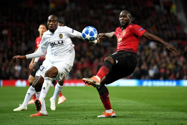 Romelu Lukaku of Manchester United is challenged by Geoffrey Kondogbia of Valencia during the Group H match of the UEFA Champions League between Manchester United and Valencia at Old Trafford on October 2, 2018 in Manchester, United Kingdom. (Oct. 1, 2018 - Source: Michael Regan/Getty Images Europe)