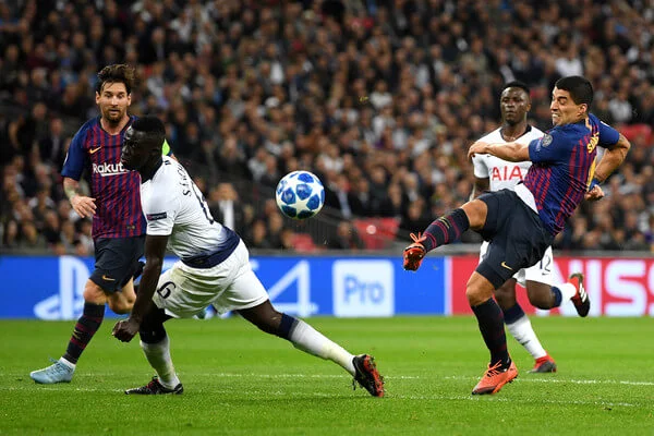 Luis Suarez of Barcelona shoots while under pressure from Davinson Sanchez of Tottenham Hotspur during the Group B match of the UEFA Champions League between Tottenham Hotspur and FC Barcelona at Wembley Stadium on October 3, 2018 in London, United Kingdom. (Oct. 2, 2018 - Source: Shaun Botterill/Getty Images Europe)