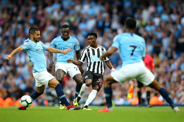 Christian Atsu of Newcastle United is challenged by Ilkay Gundogan of Manchester City and Benjamin Mendy of Manchester City during the Premier League match between Manchester City and Newcastle United at Etihad Stadium on September 1, 2018 in Manchester, United Kingdom. (Aug. 31, 2018 - Source: Alex Livesey/Getty Images Europe)