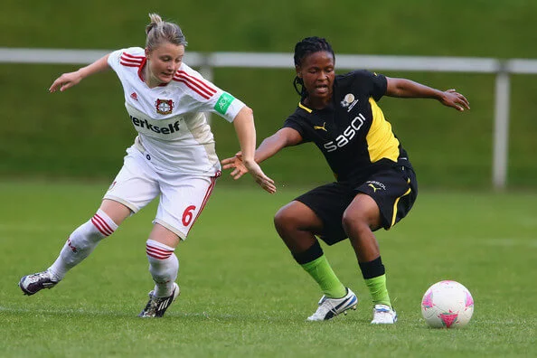 Claudia Goette of Leverkusen challenges Amanda Dlamini of South Africa during the women's friendly match between South Africa and Bayer Leverkusen at Sport School Hennef on July 12, 2012 in Recklinghausen, Germany. (July 11, 2012 - Source: Christof Koepsel/Getty Images Europe)