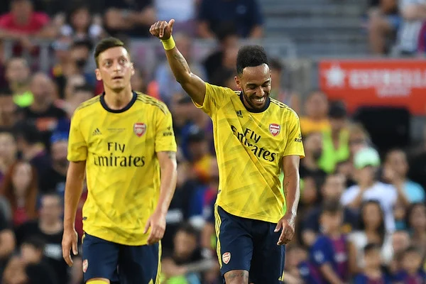 Pierre-Emerick Aubameyang of Arsenal celebrates with his tem mate Mesut Ozil after scoring his team's first goalduring the Joan Gamper trophy friendly match between FC Barcelona and Arsenal at Nou Camp on August 04, 2019 in Barcelona, Spain. (Aug. 3, 2019 - Source: Getty Images Europe)
