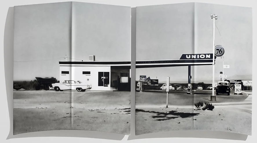Black and white photo of a vintage gas station with a sign reading "Union" and several cars parked around.