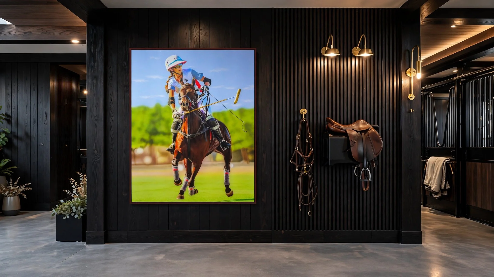 Interior of a room with black wooden walls, decorated with a large colorful poster of a female jockey riding a horse, and with equestrian equipment hanging on the wall.