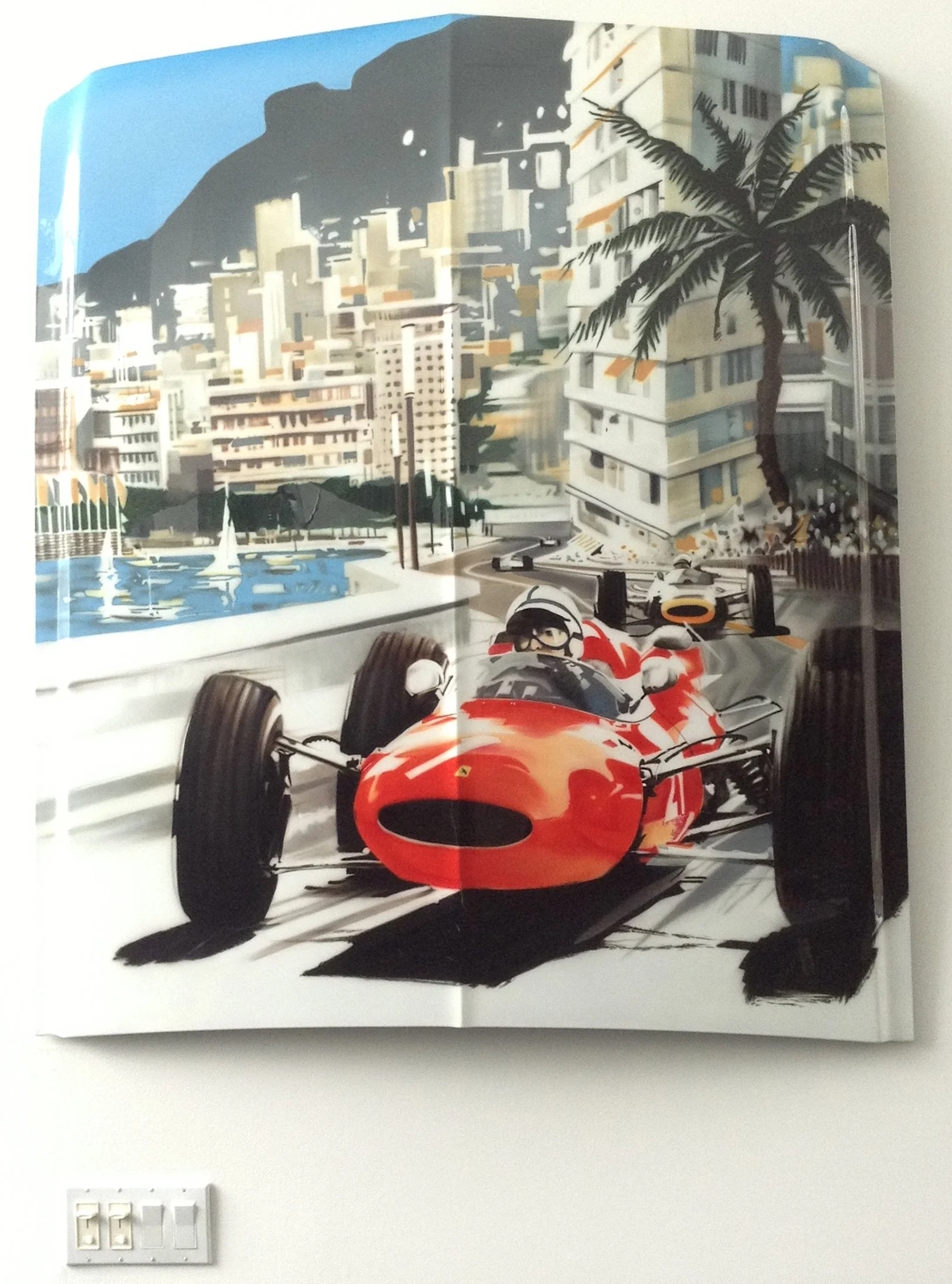 A mural or painting of a cityscape with tall buildings, mountains in the background, a palm tree, a pool with sailboats, and a racing car in the foreground.