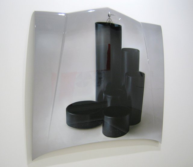 Black cylindrical and rectangular objects arranged on a white surface.