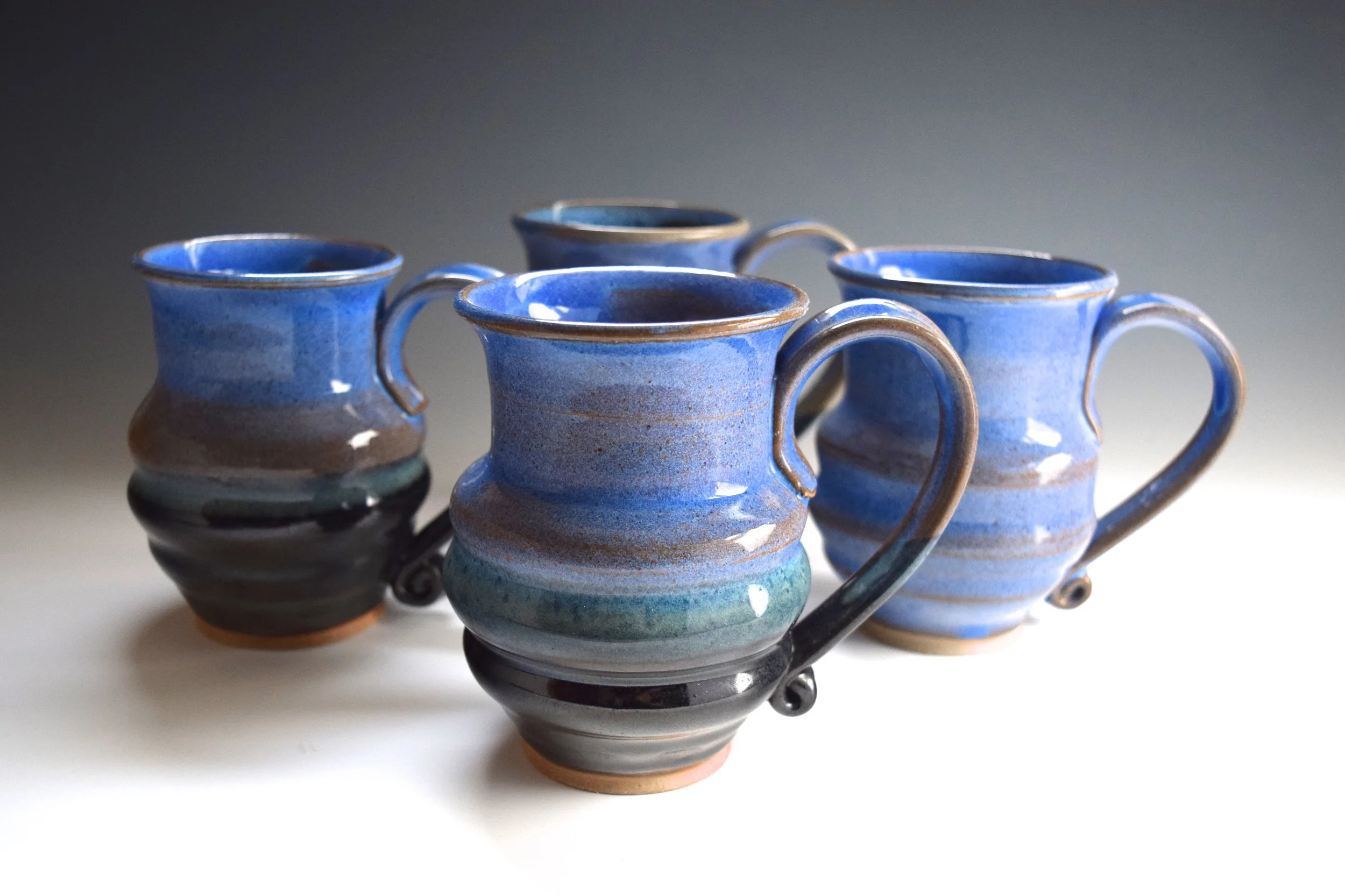 12 fl oz Coffee Mugs. 4.75” Tall. The ribbed body of this shape nestles comfortably in your hand. The rims are curved to match the profile of your lip and a large handle lets you get all four finger in for a secure grip.