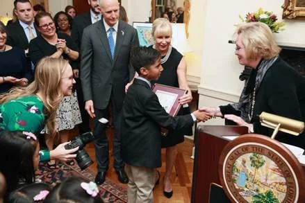On behalf of Florida Prepaid, Cynthia O’Connell awards scholarships to Hispanic Heritage Month Essay Contest winners.
