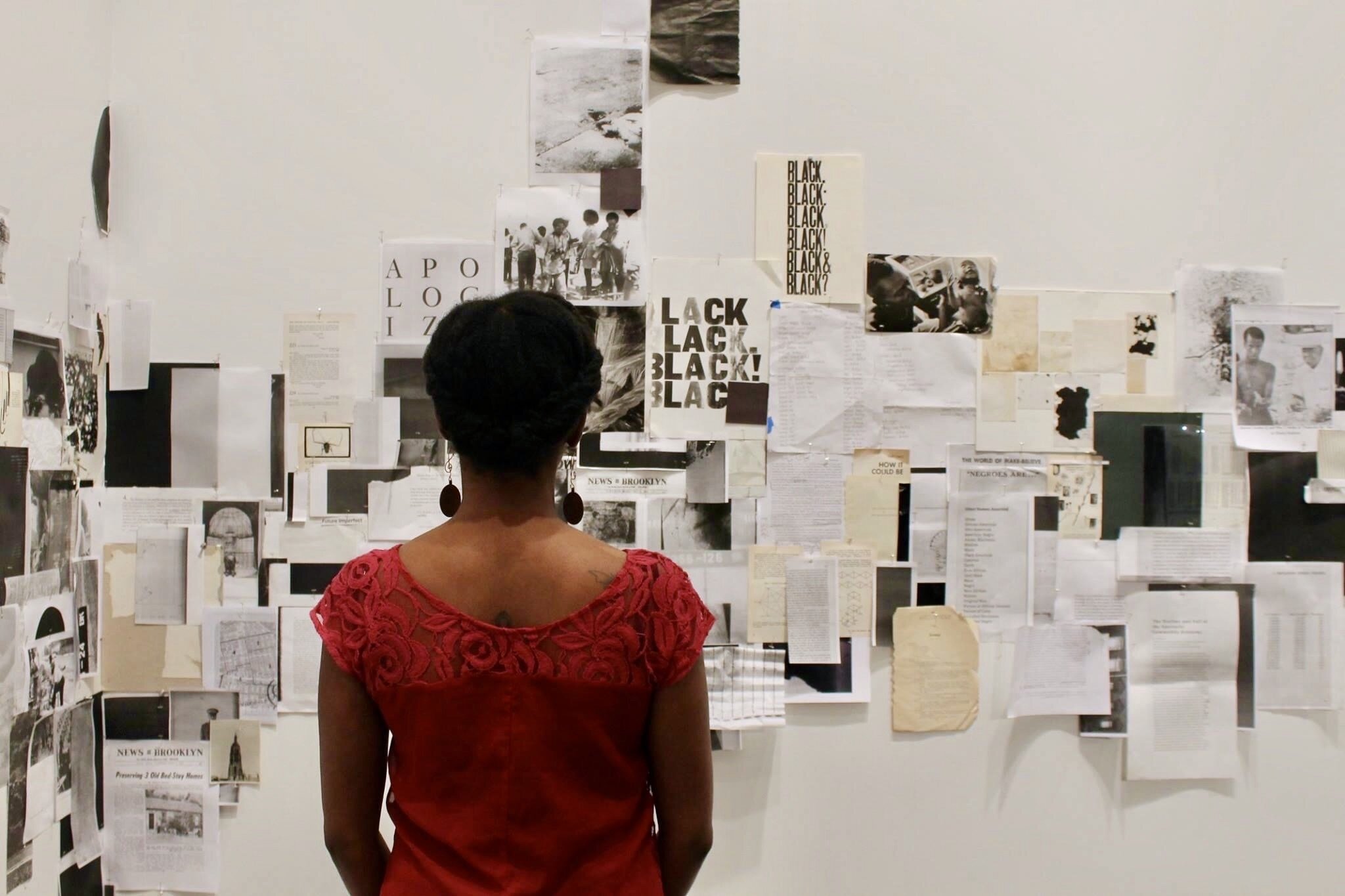 Stephanie Cunningham standing in Kameelah Rasheed’s 2015 Future Perfect exhibition at Weeksville Heritage Center in Brooklyn, New York.