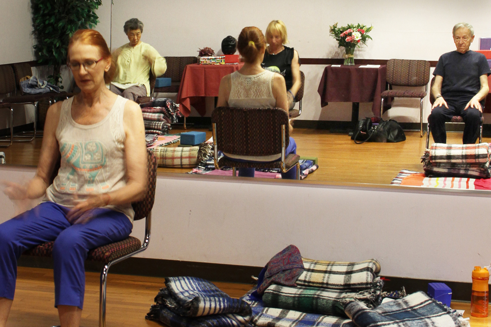 reflection of students learning the basic chair pose.jpeg