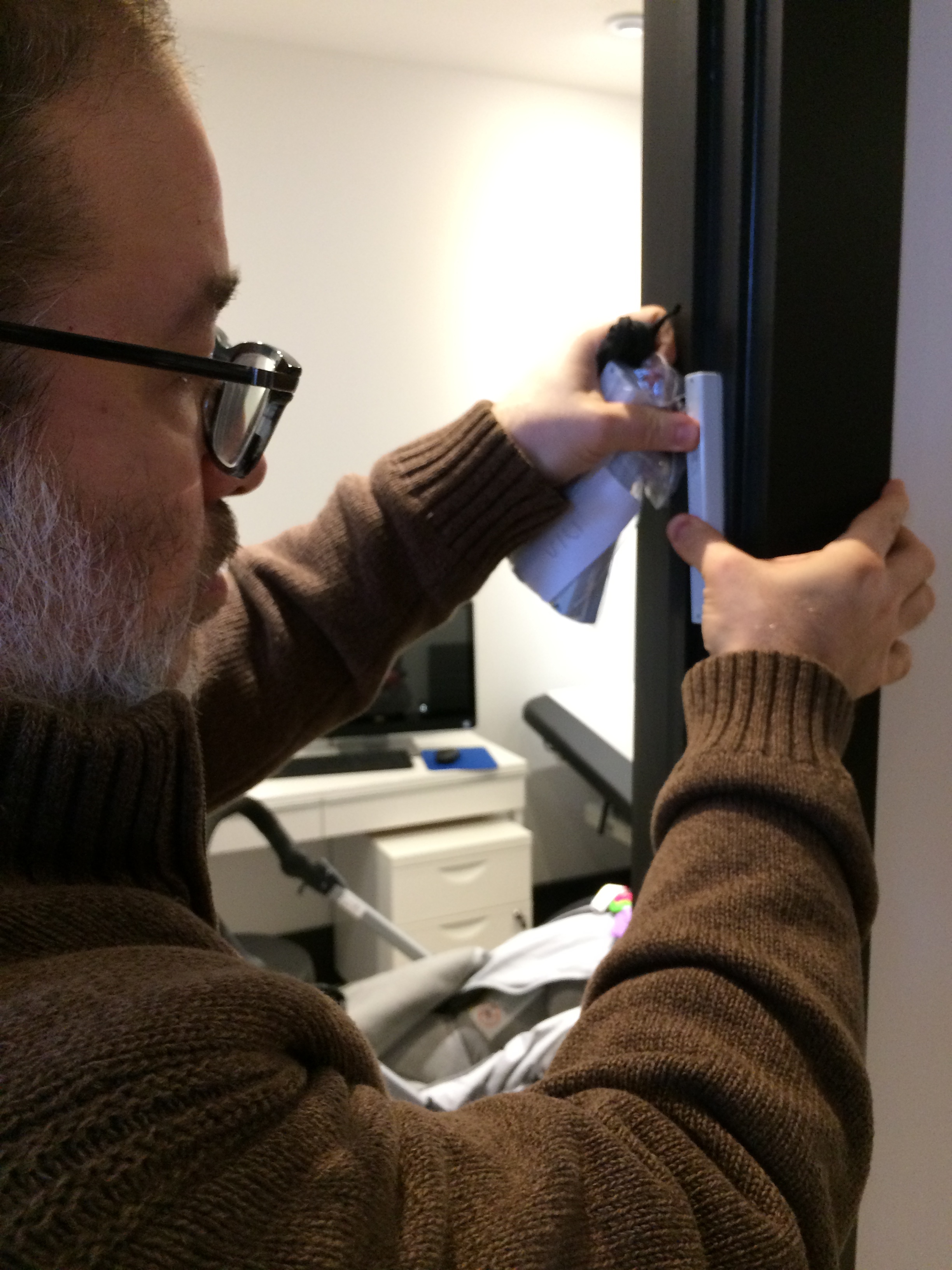 Tomer Meldung, RM Rivky Meldung’s partner, affixes a mezuzah to one of our clinic doorways during Uptown Midwives Open House.