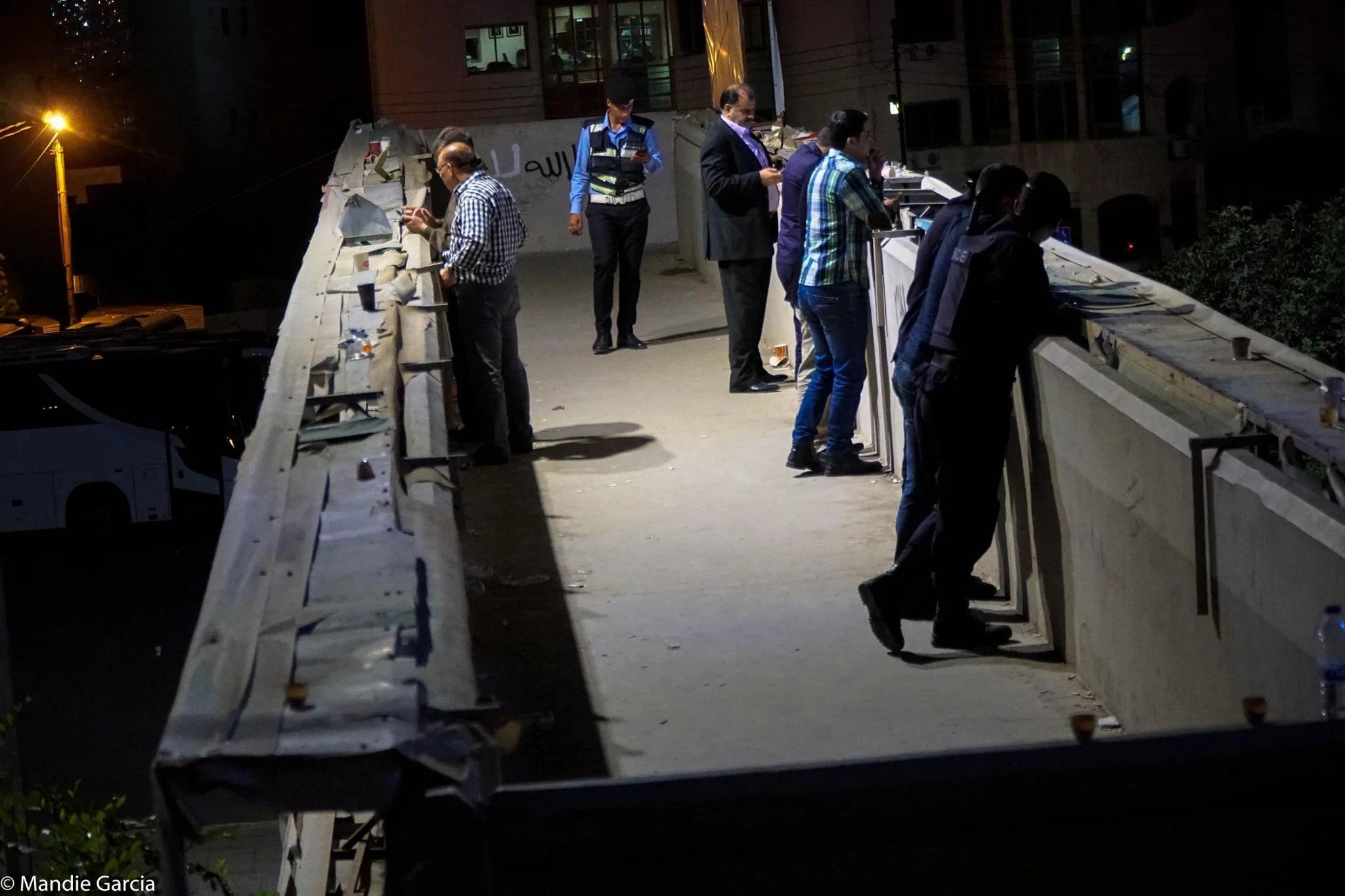 Security forces watch the protest from an elevated crosswalk between buildings.
