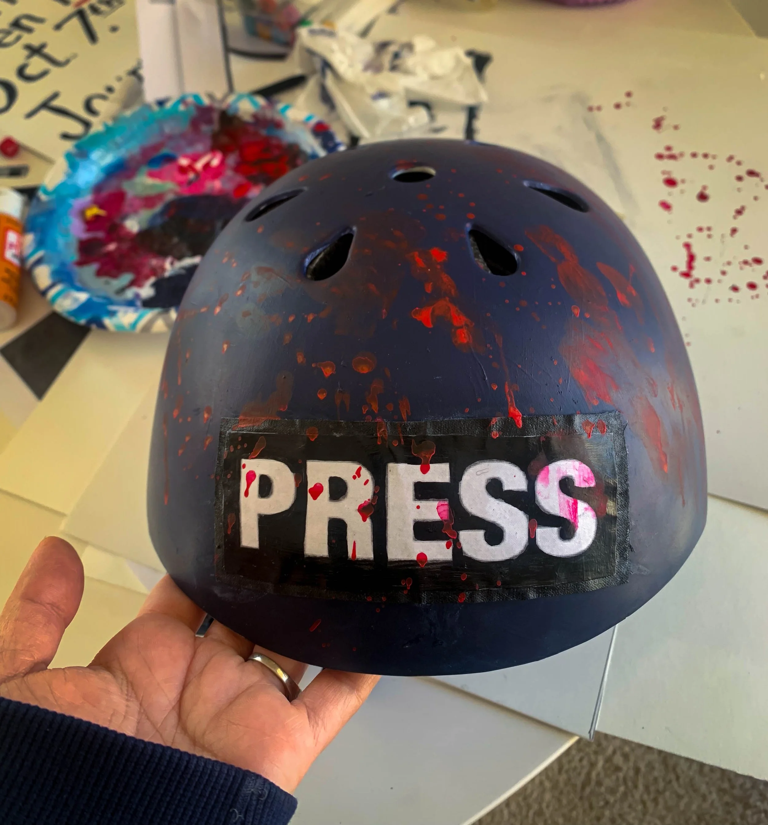 Bloody press helmets for a protest on journalists killed in Gaza and Lebanon.