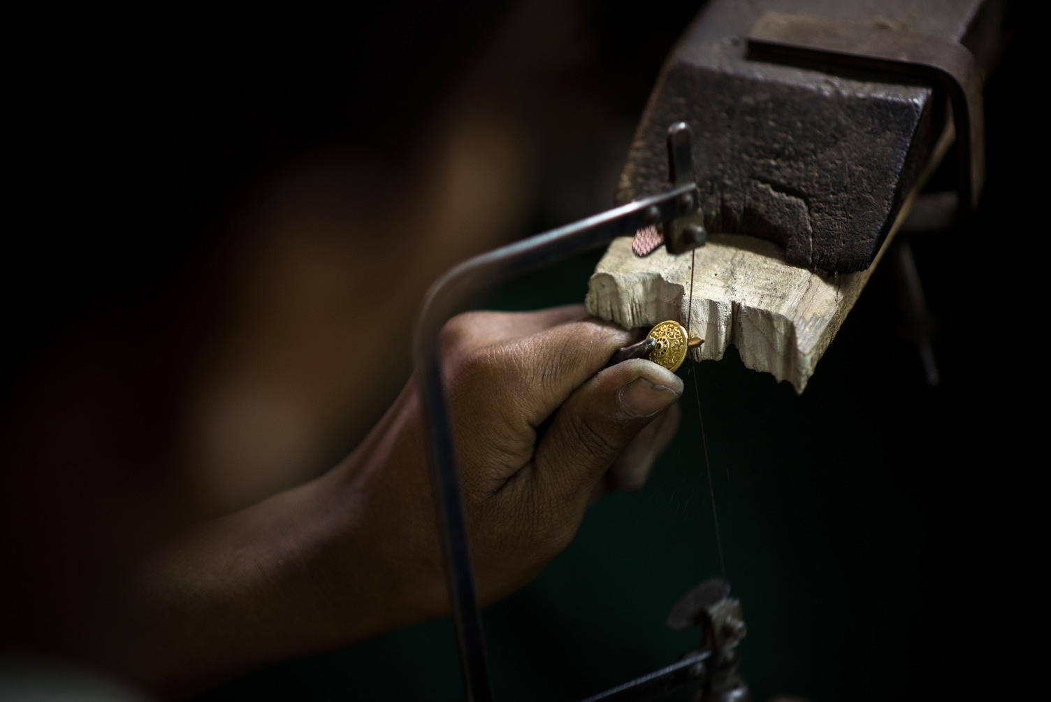 ARTISAN FILING A PIECE TO CREATE A BEAUTIFUL HANDCARFTED BUTTON