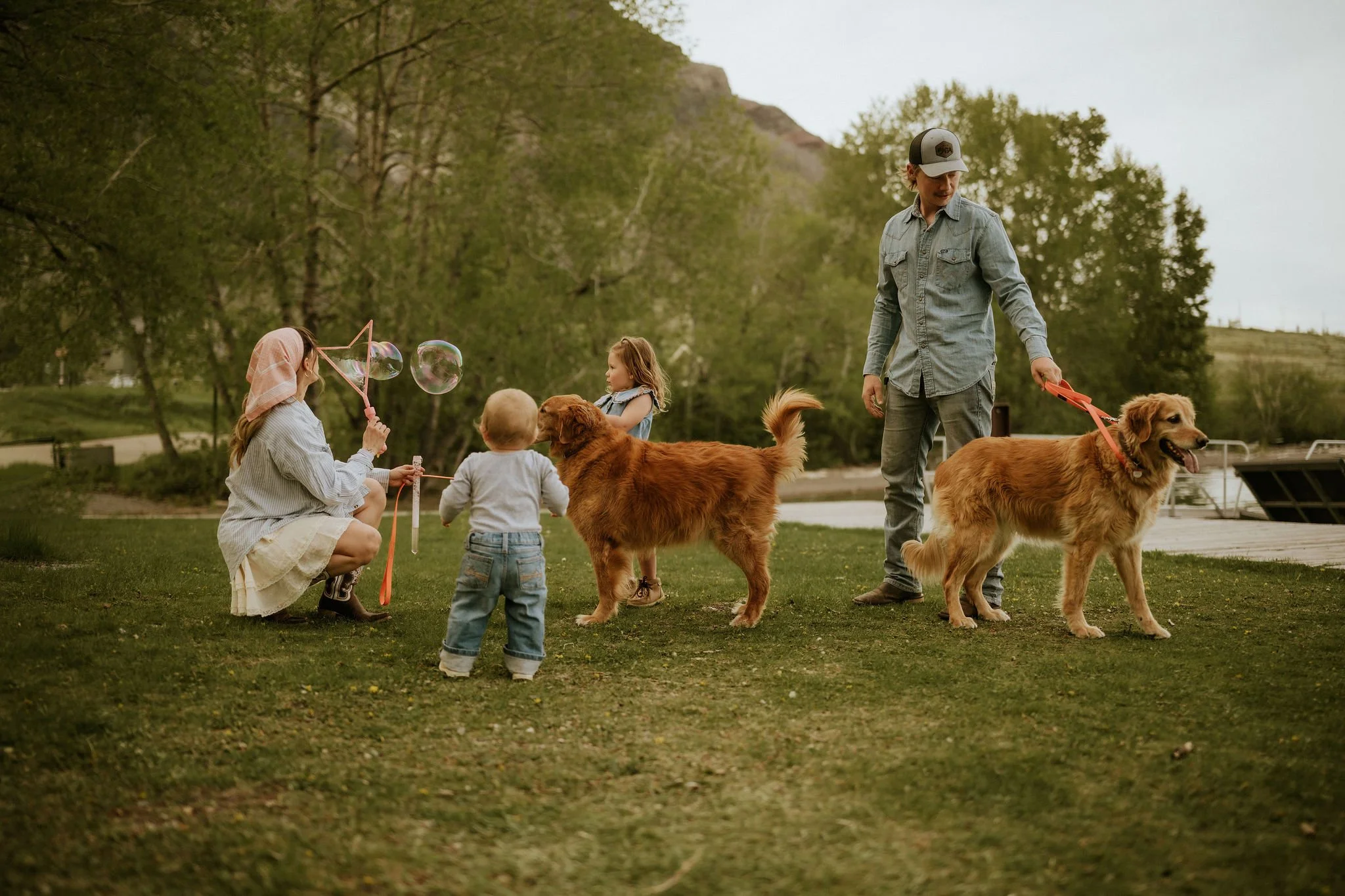 family blowing bubbles with child, toddler, and puppys  in Waterton lakes national park