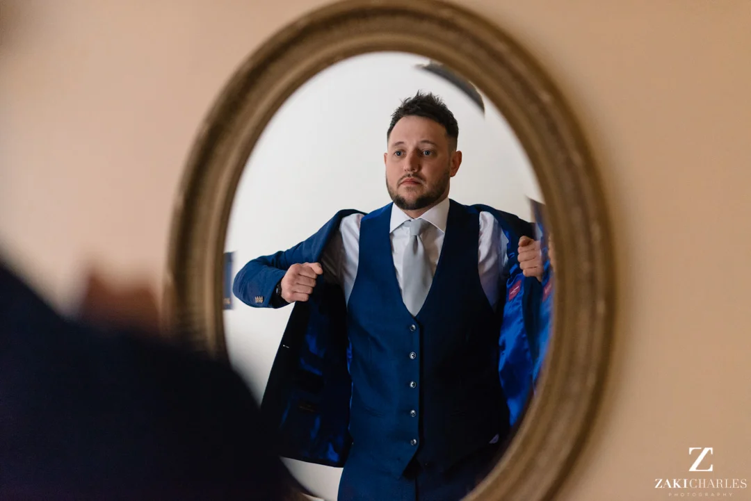 Action shot of groom putting on his jacket