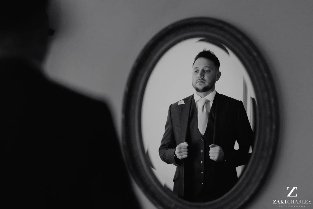 Action shot of groom putting on his jacket