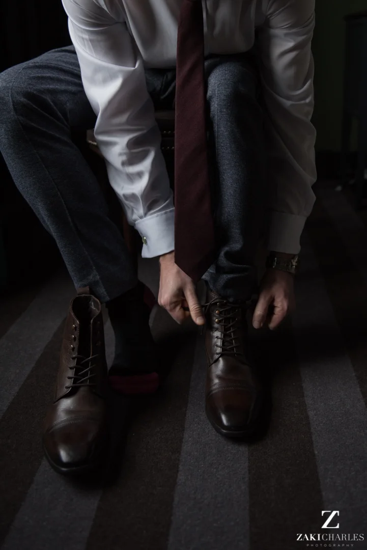 Groom tying up his shoes at the crown and thistle 