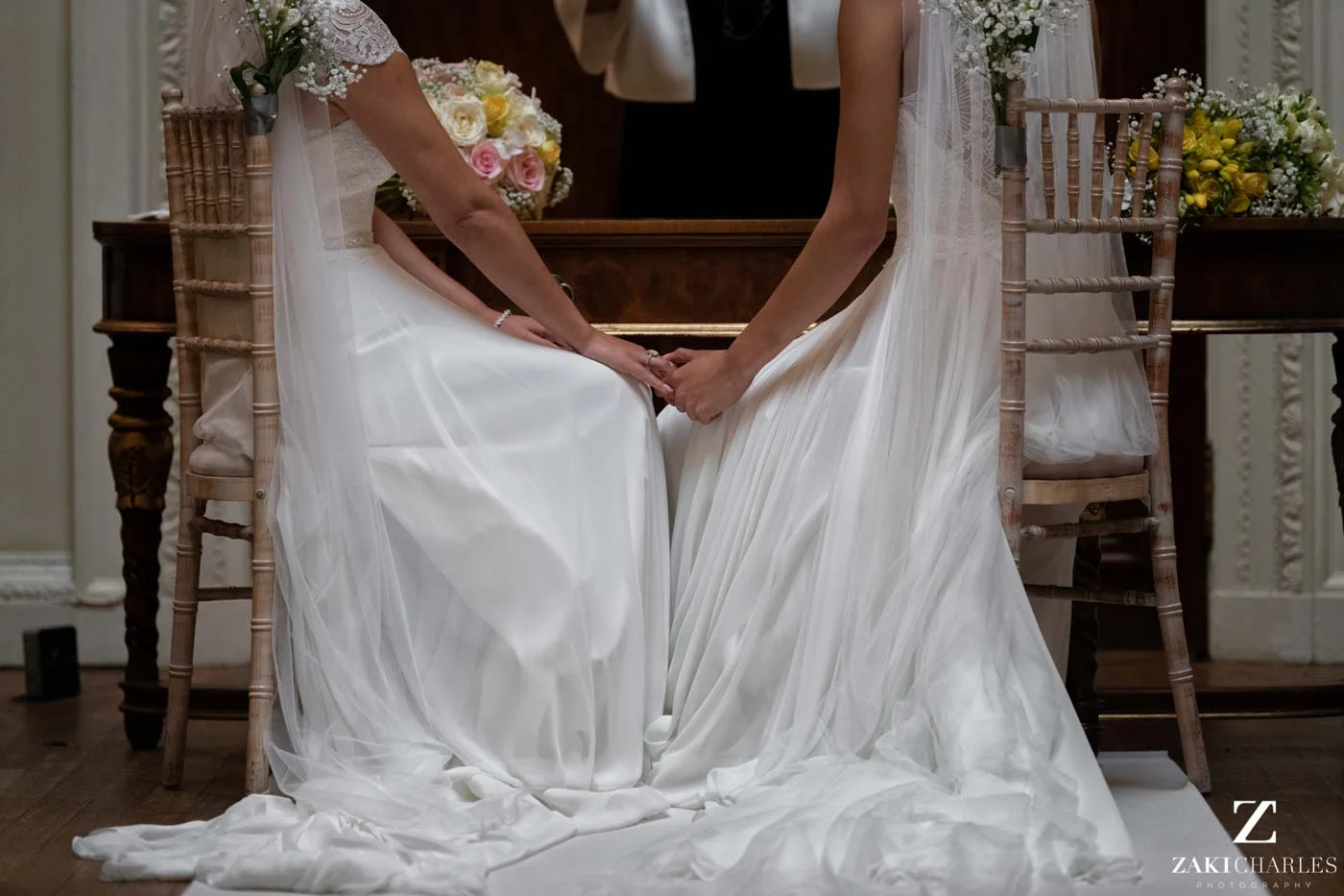 Brides holding hands during ceremony at Hedsor House photo