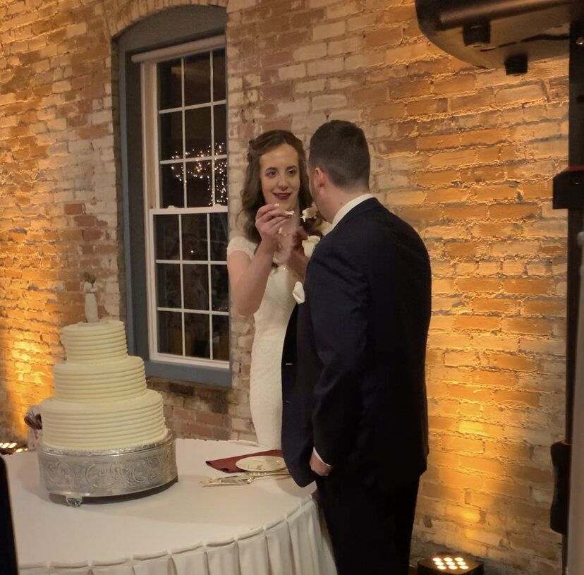 Cake cutting with golden yellow uplights in Goshen IN