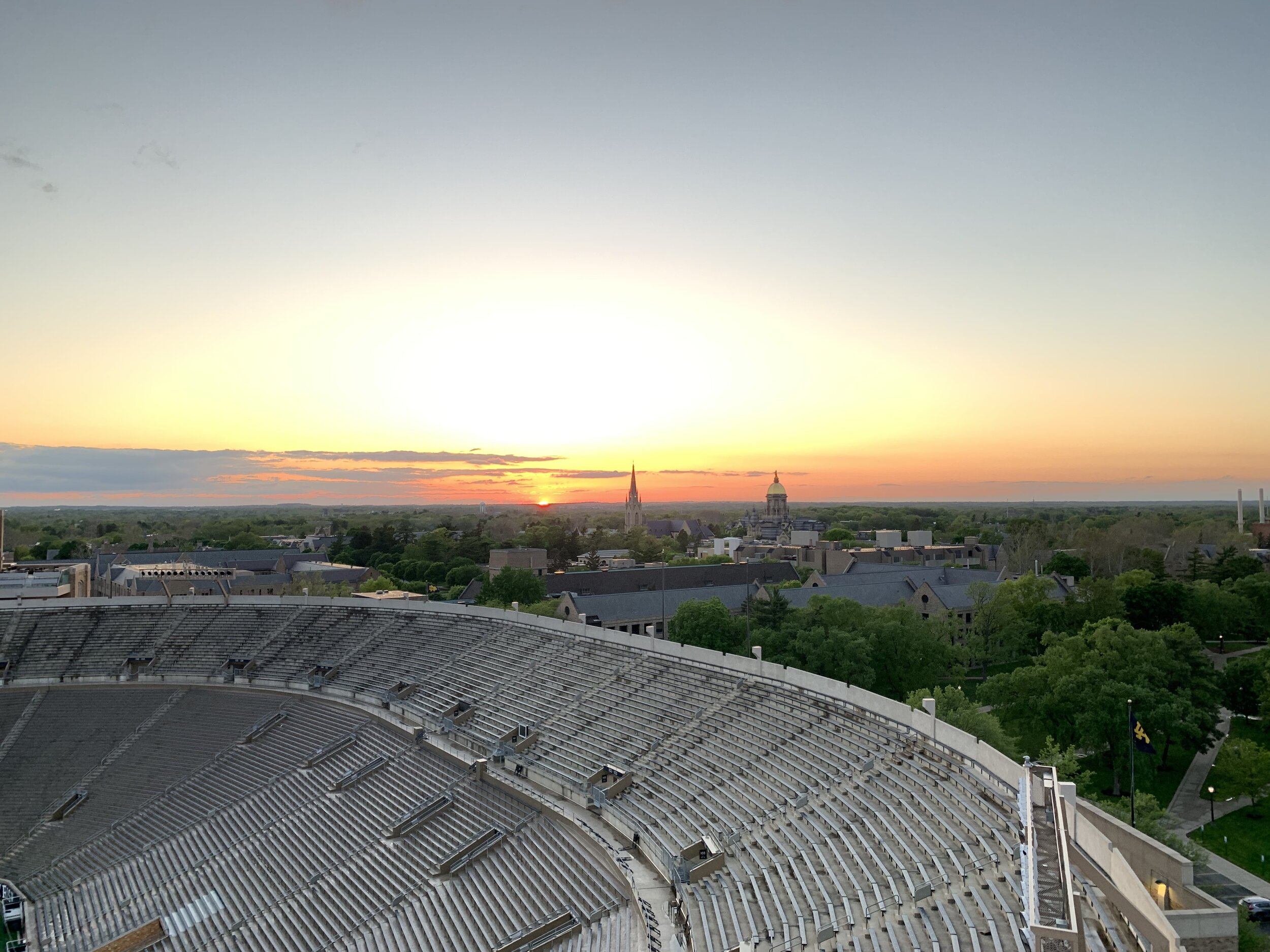Notre Dame Stadium graduation sunset with Golden Dome and Basilica