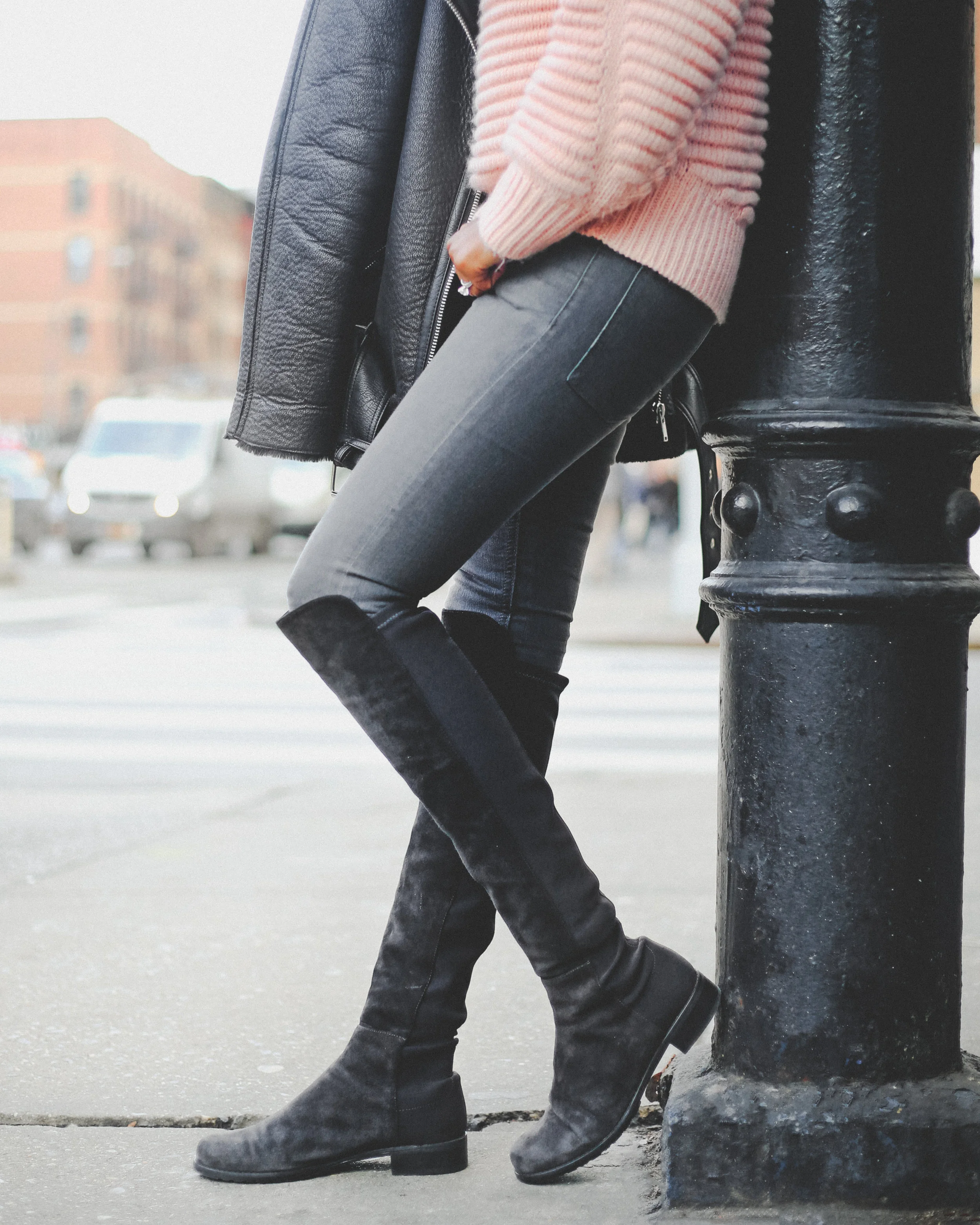Krys modeling fall attire leaning against a street pole.