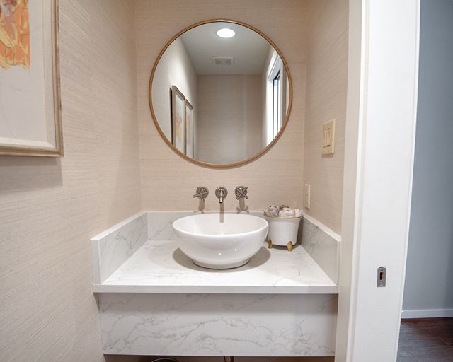 We revamped this powder bath with some new natural woven wall covering from Innovations, a new quartz vanity, and this cool above counter sink. We also mixed in some gold with the mirror and the artwork frames. #interiordesign #powderbathdesign #inno