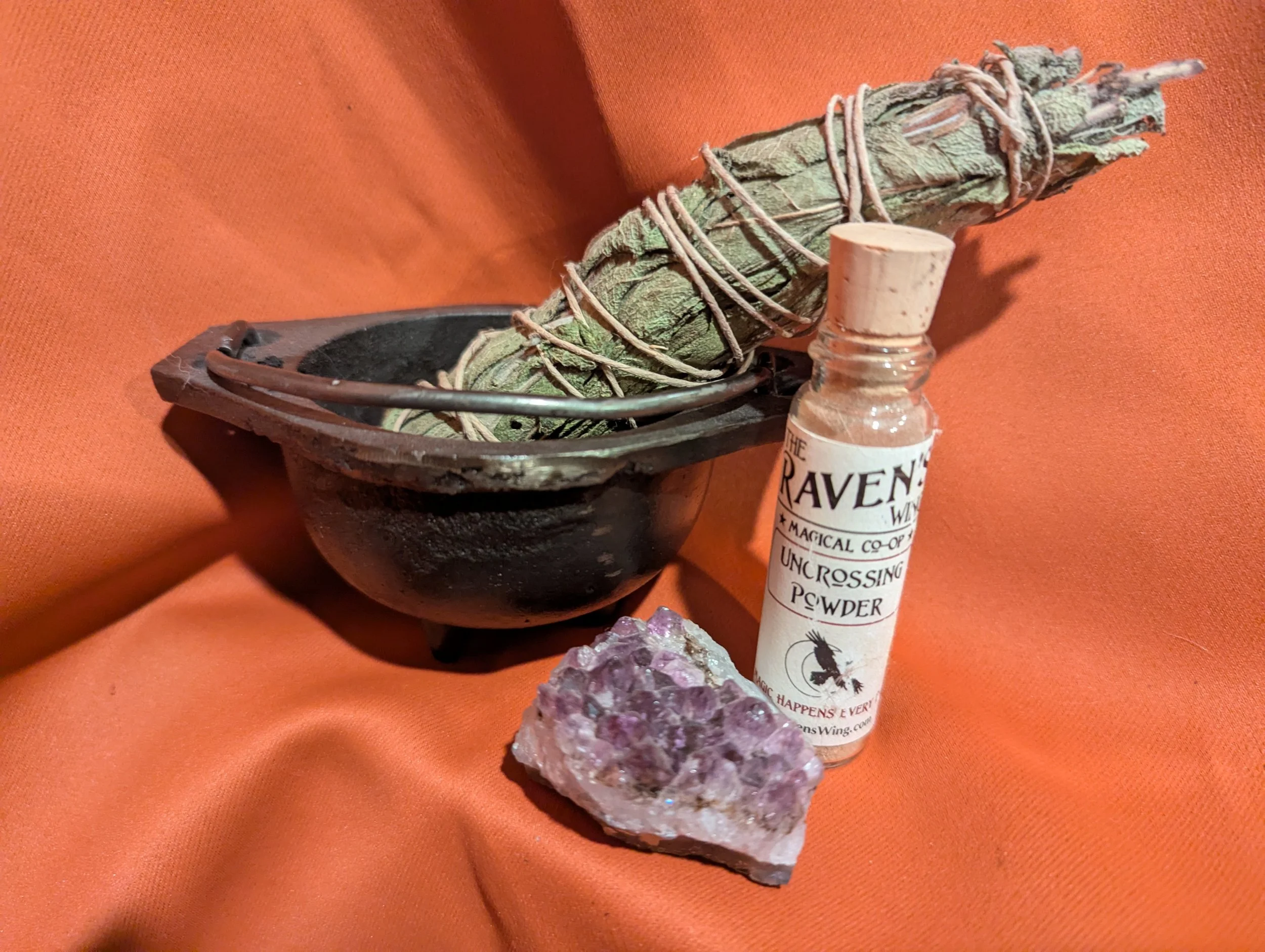 Garden sage bundle in a small cauldron, amethyst geode, and Raven’s Wing Uncrossing Powder