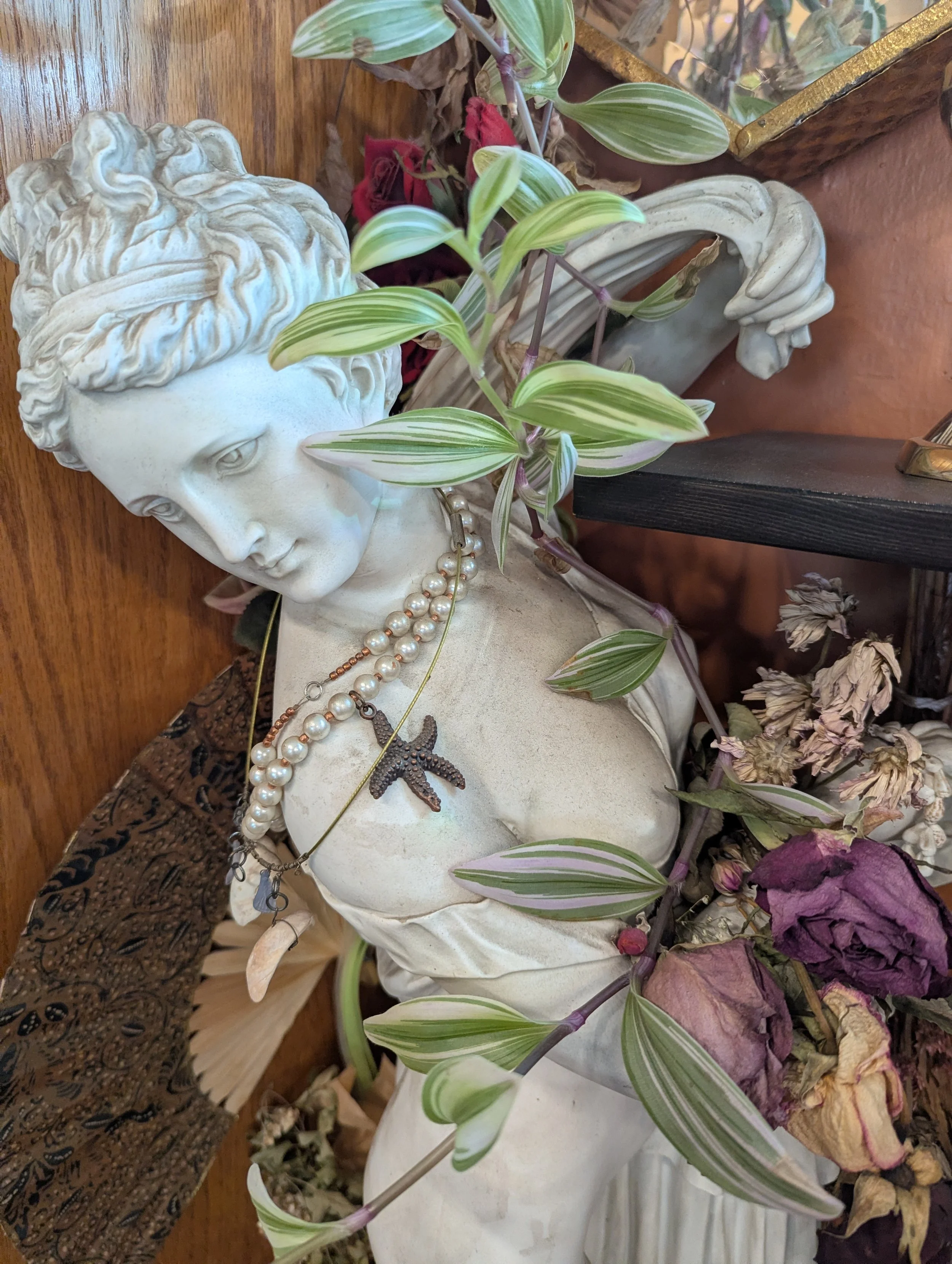 statue of Venus on her altar with pearls vines and flowers