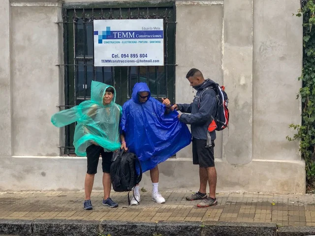 Kapil helping his parents with rain ponchos, two hours after the hottest/stickiest climate!