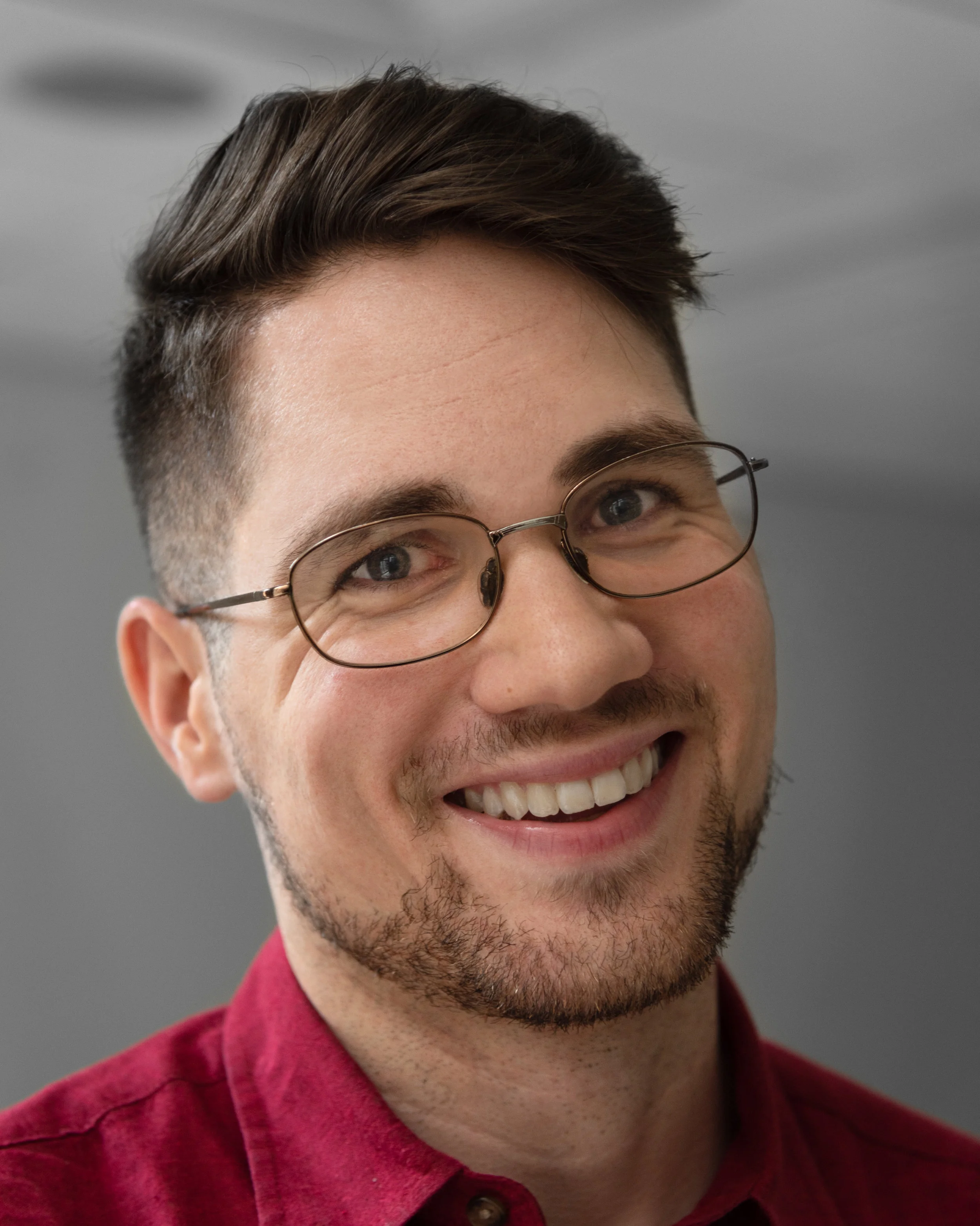 Donnie Welch, a young white man with glasses, smiles at the camera for a head shot style photo. (This photo and "Services" page photo by Julie Nash)