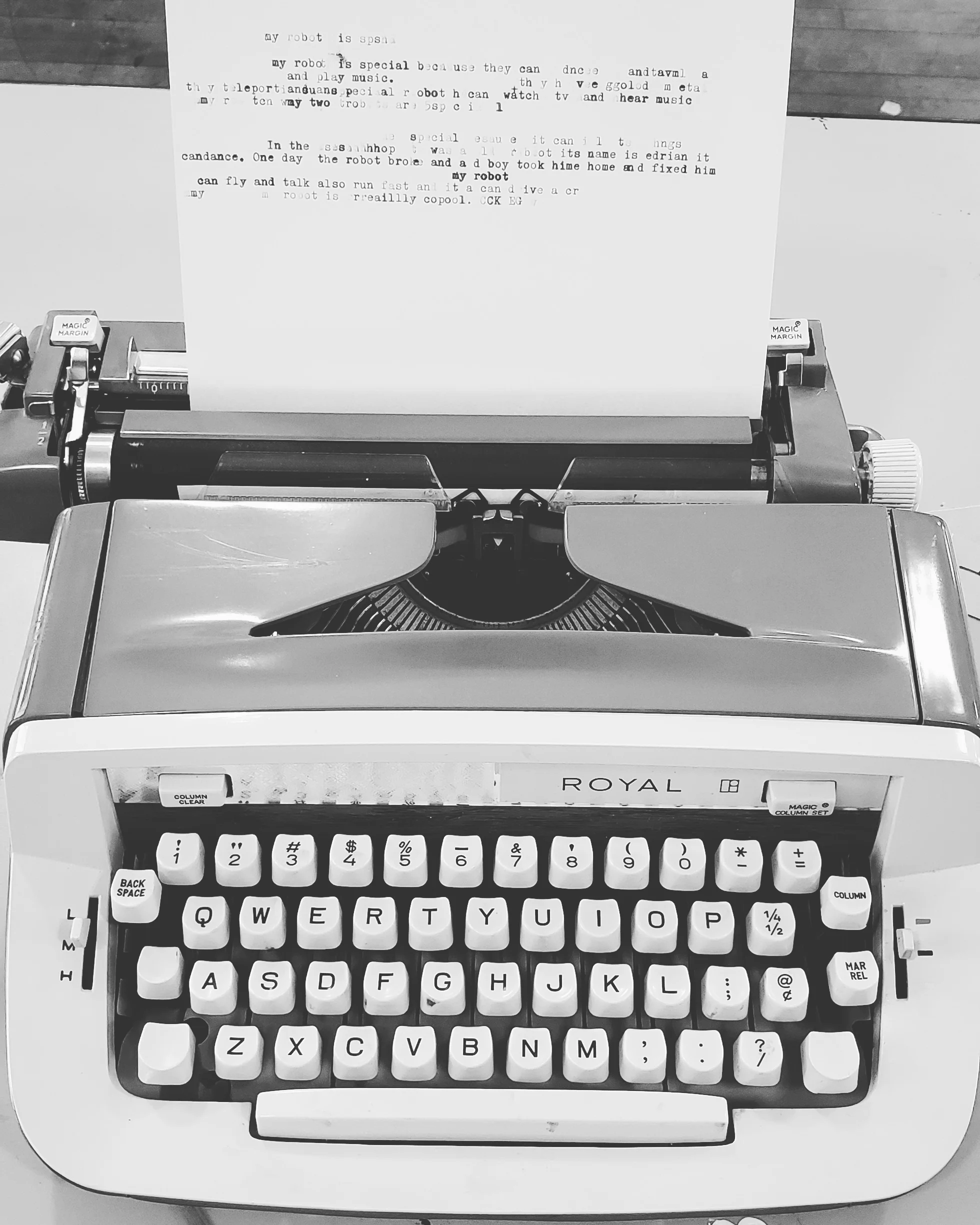 Black and White photo of a 1970s typewriter. A paper with some typing is loaded into the scroll.
