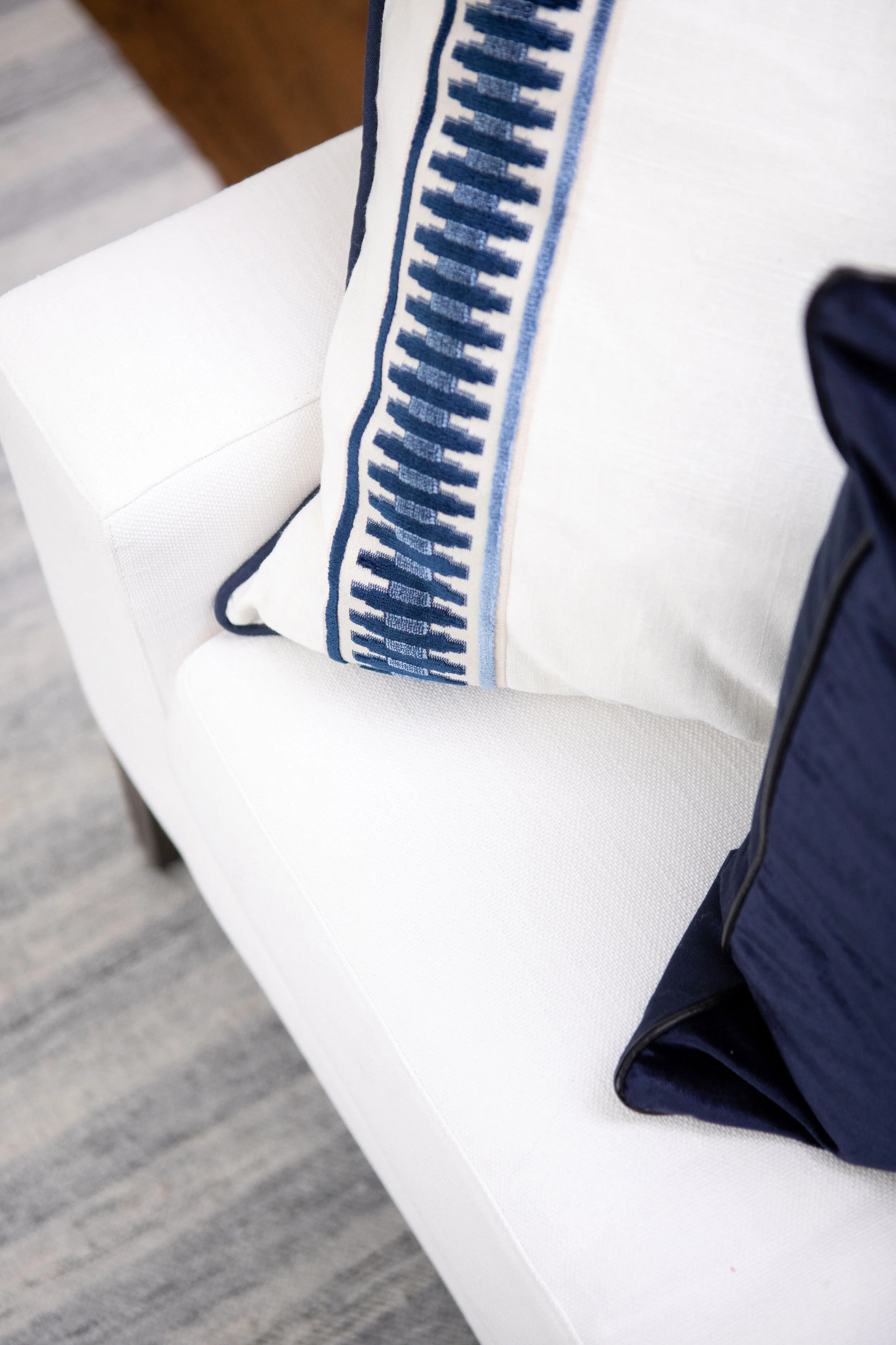 We love the detail on these hand-stitched, satin-banded throw pillows in the Living Room with velvet pipe detailing around the perimeter.