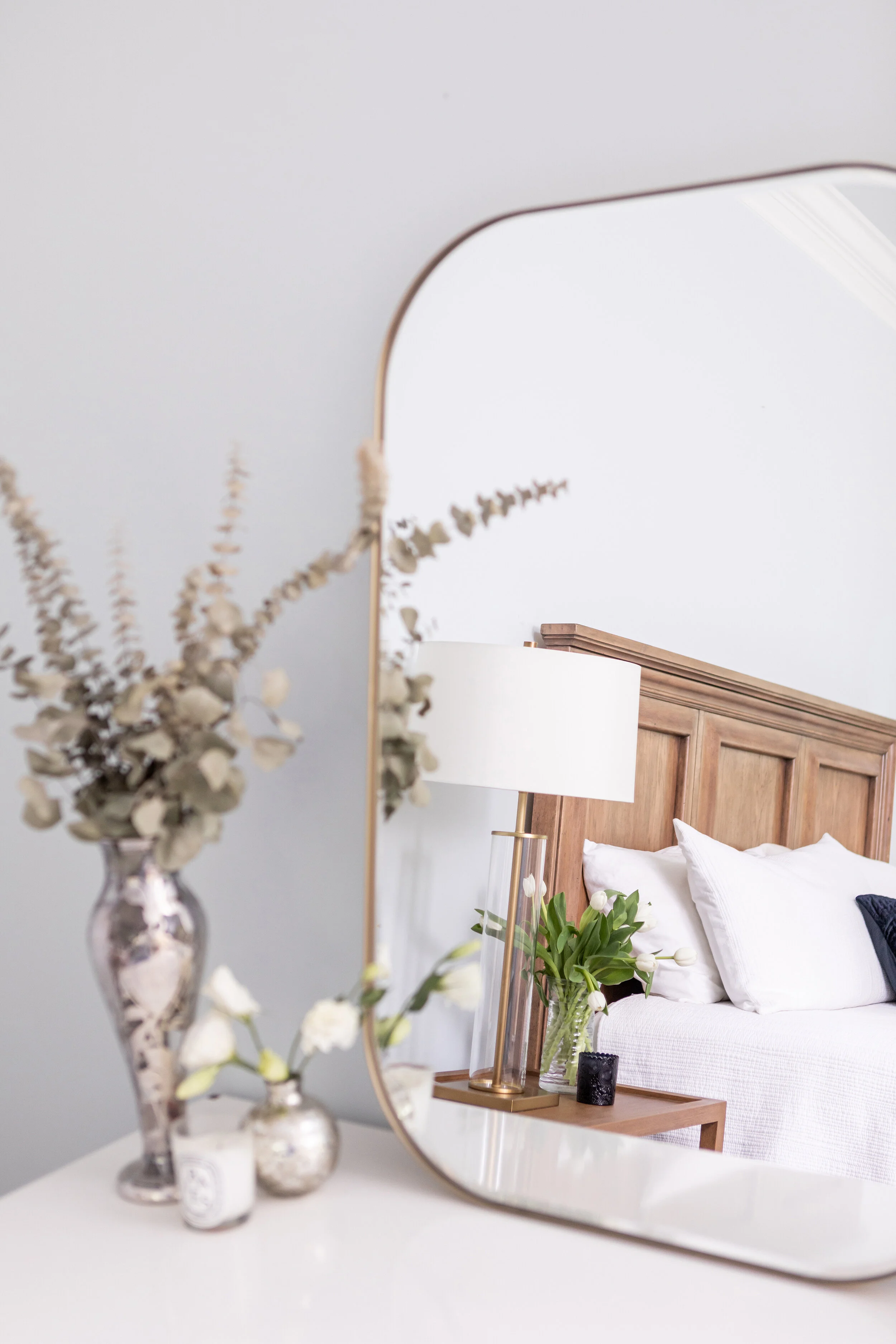 Nickel accents in the vases on the vanity in the Main Bedroom softly pair with the large brass framed make up mirror.