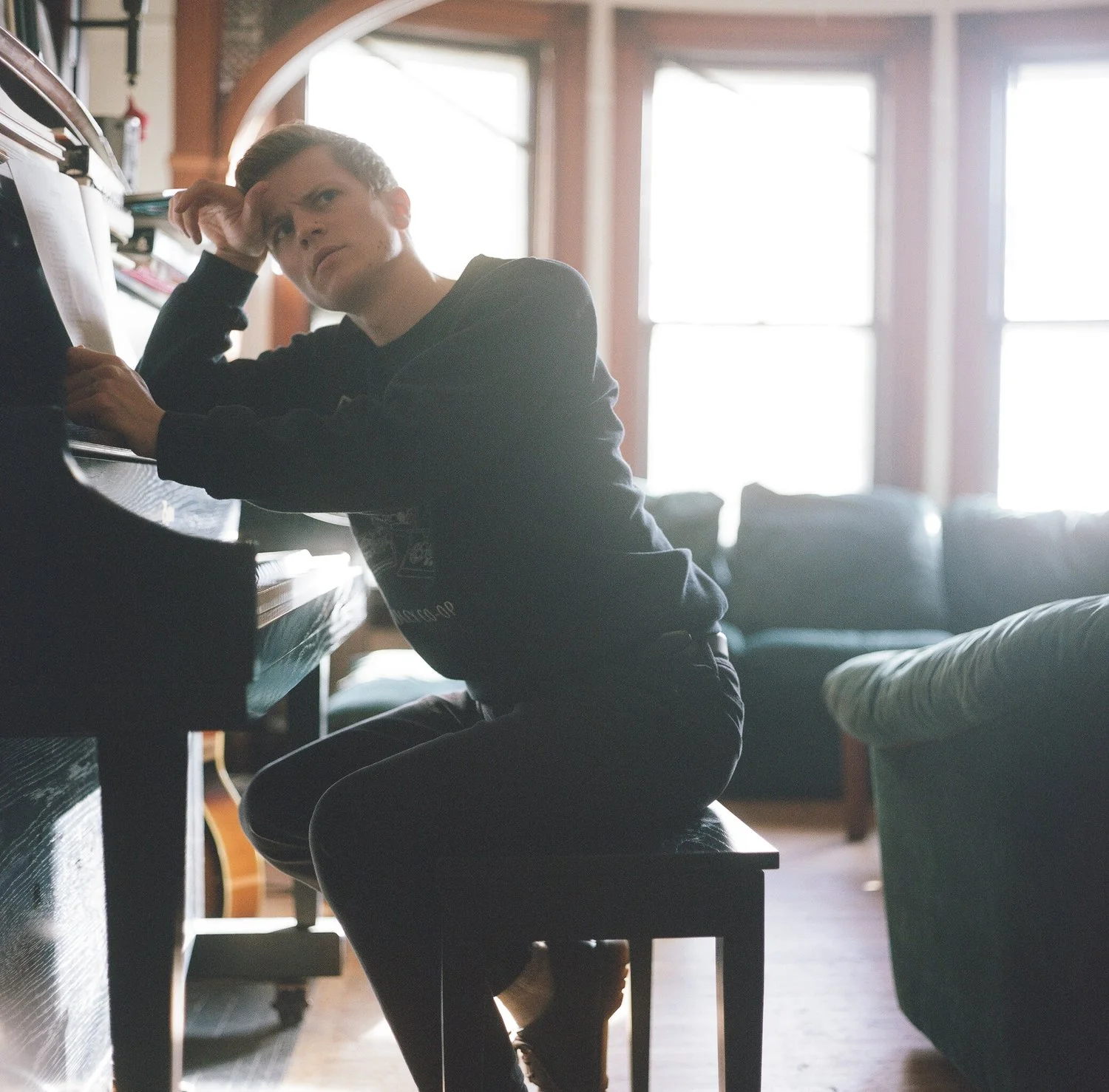 Daniel looks deep in thought at the piano in the living room 2, shot on a Mamiya C330 with Kodak Portra 120, 2017.