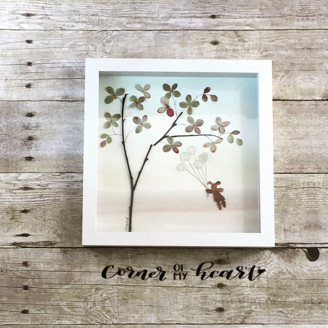 Girl holding balloons floating, with tree