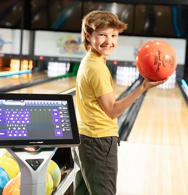 boy-smiling-at-fin-city-bowling-with-ball.webp