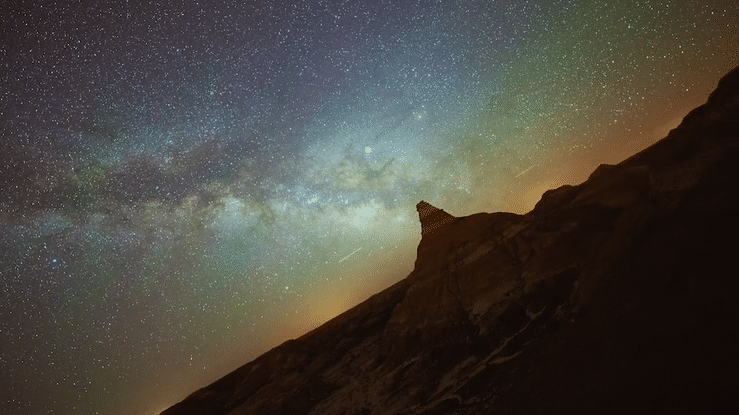 Night sky showing the Milky Way galaxy over a mountain ridge.